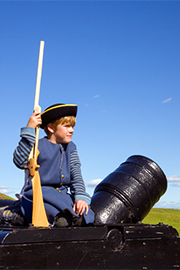 Boy sitting on cannon at Ft. Beausejour National Historic Site