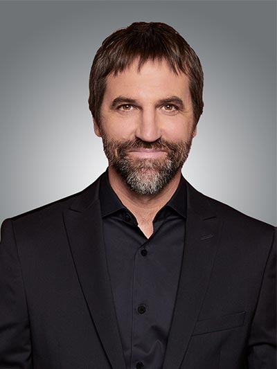 Headshot of the Honourable Minister Steven Guilbeault. He has brown eyes, and a brown beard and hair and is wearing a black shirt.