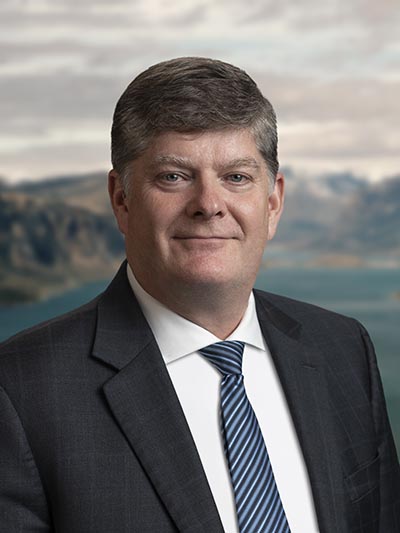 Headshot of Parks Canada President and CEO Ron Hallman. He has blue eyes and gray hair and is wearing a suit and tie.