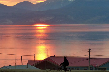Boy on bike with arctic town and landscape in background