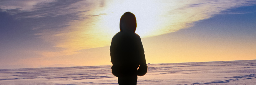Figure in parka looking at a sunset