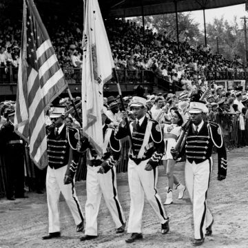 A group of men walking in a group carrying flags