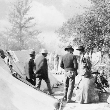 Black and white photo of workers at their camp site