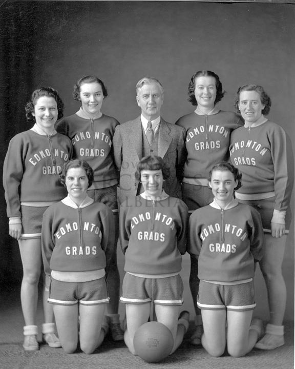 Black and white photo of a group of women and a basketball