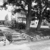 Black and white photo of a house in a neighborhood