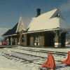 A railway station with snow on roof and a blue sky