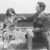 Historical photo of a man and a dog seated