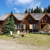 Photo of a rustic log cabin, trees and blue sky