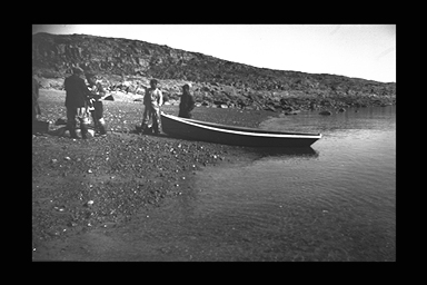 Black and white image of boat on shore