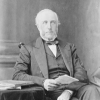 Black and white photo of the portrait of a man seated