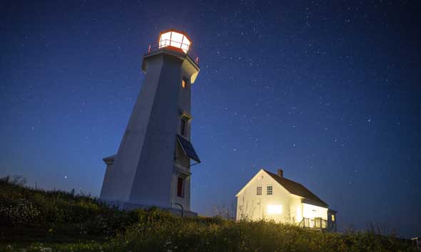 Lighthouse station and lighthouse keeper’s house on Île aux Perroquets, at night. Mingan Archipelago National Park Reserve