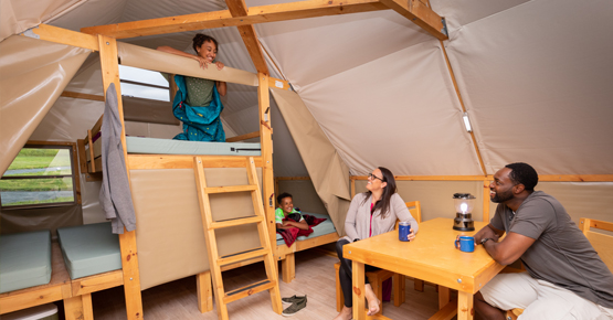 the interior of the oTENTik features bunk beds and a sitting area