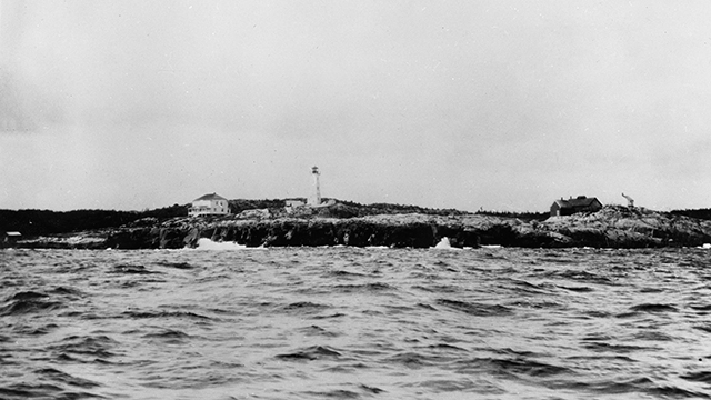 Photo take from a boat looking towards the Lighthouse Point lighthouse, and the caretaker and assistance's houses. 