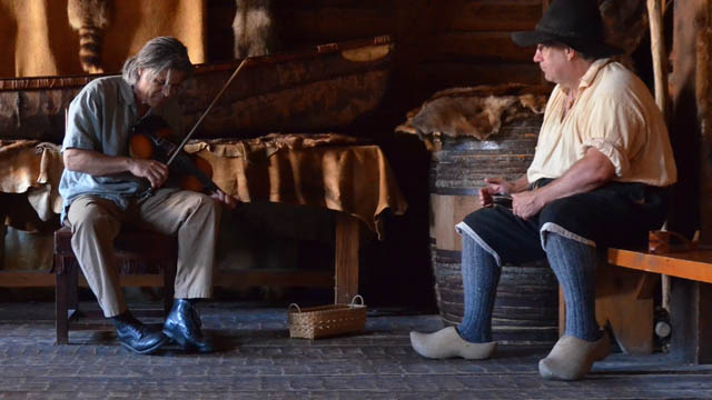 A man with a fiddle and a man with wooden shoes.
