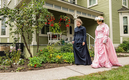 Walking in historic cloths in front of the historic house