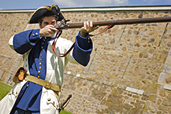 A French soldier prepares to fire the musket at Fort Chambly