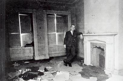 Eric D. McLean standing beside the fireplace