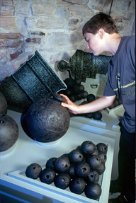 A boy takes a peek inside an old iron bomb