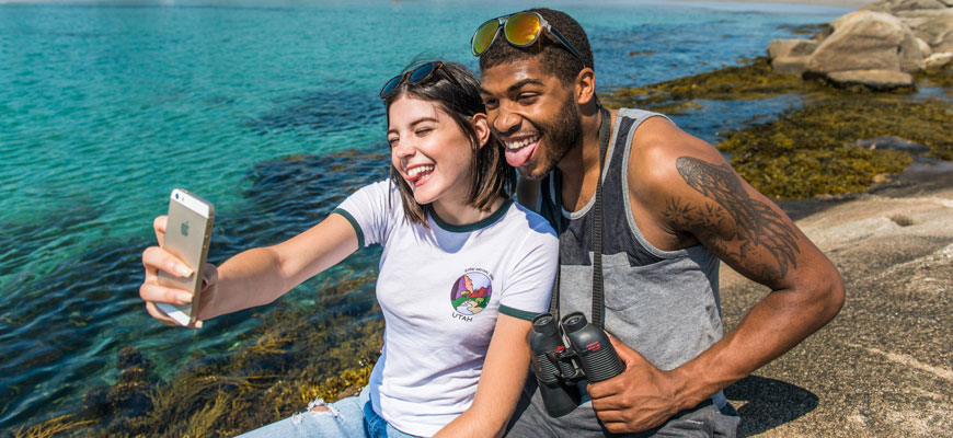 A couple takes a selfie by the shore.