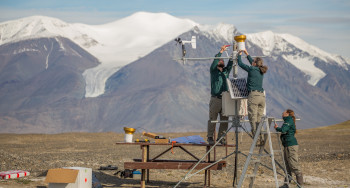 Parks Canada Resource Conservation staff performing maintenance on a weather station 