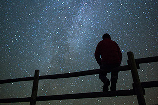 A visitor enjoying the breathtaking views of the Milky Way at night from the Frenchman Valley Campground in the Dark-Sky Preserve, Grasslands National Park