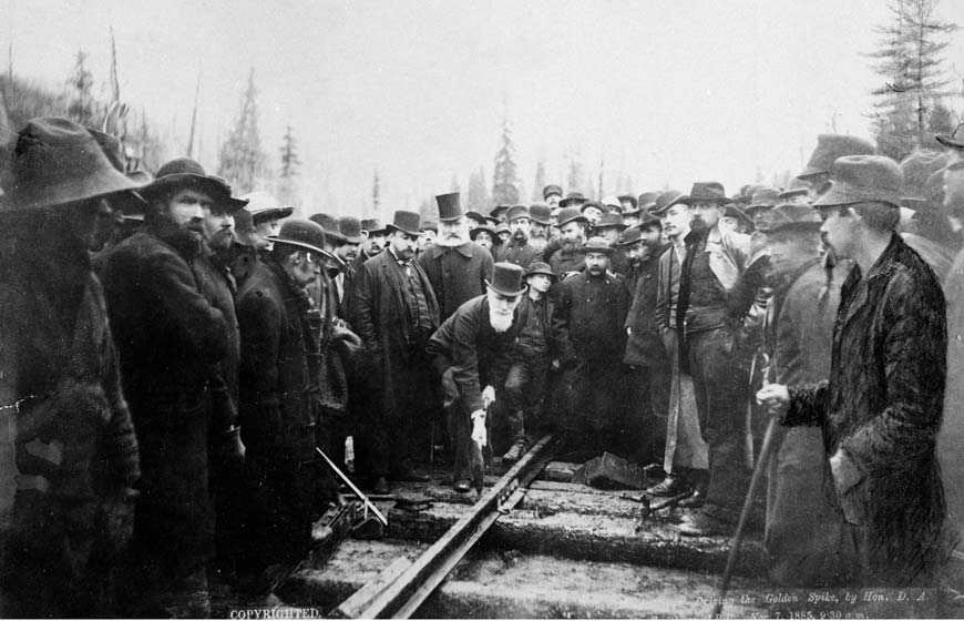 Famous image of the last spike being driven into the trans-Canada railway by an old man in a white beard and tophat. 