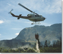 Picture of a helicopter dropping water over the Sofa Mountain fire