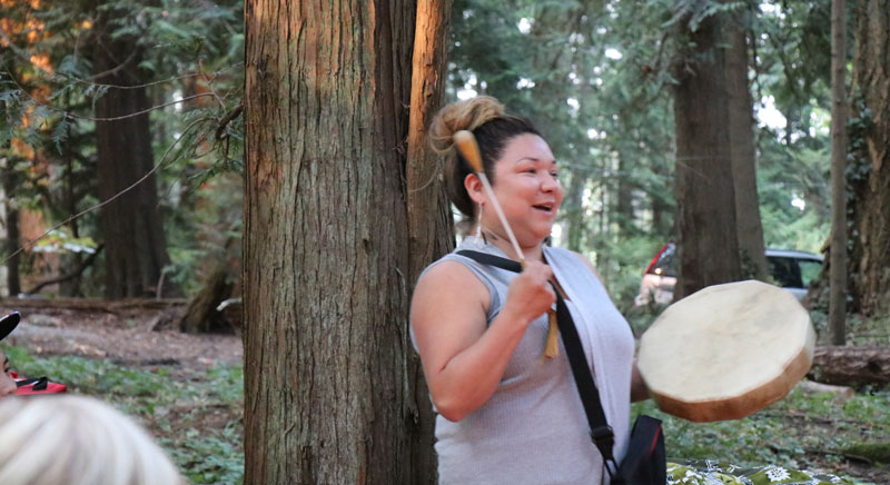 A Coast Salish storyteller sings a traditional song and plays the drum.