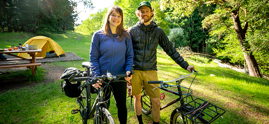 A young biker couple take a break on a bike trail