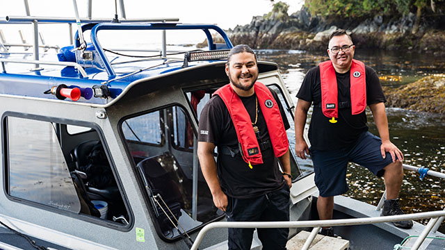 Two men standing on a boat.