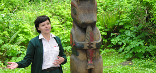A Parks Canada interpreter standing next to a post on the Nuu-chah-nulth Trail