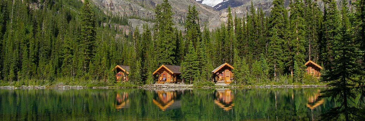 The cabins of Lake O’Hara Lodge reflect in the still waters of Lake O’Hara