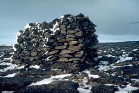 Stones are piled high on  the rocky landscape to form a cairn.