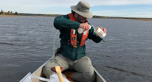 Christian Tremblay collects water samples at Whirlpool Lake to test for AIS