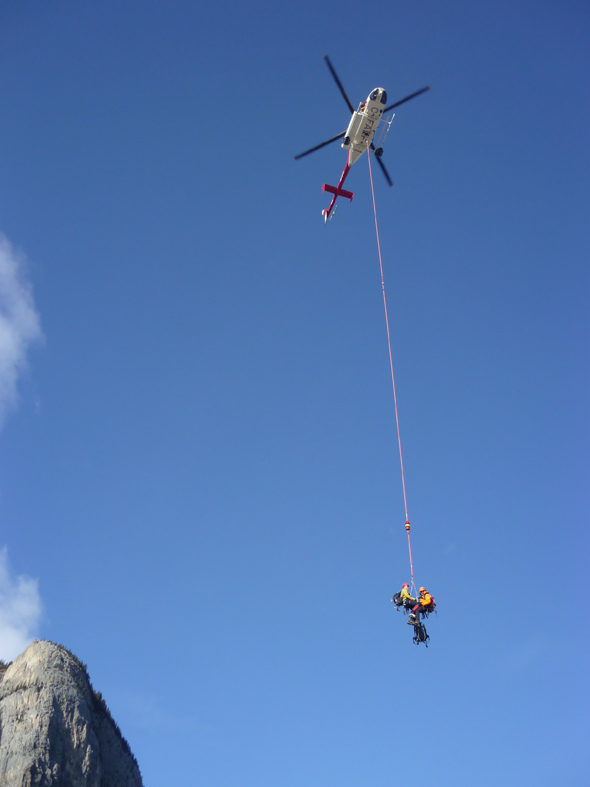 A Visitor Safety Specialist brings an injured climbers partner down to a staging area. This photo is from a live rescue on Cascade Waterfall near Banff.