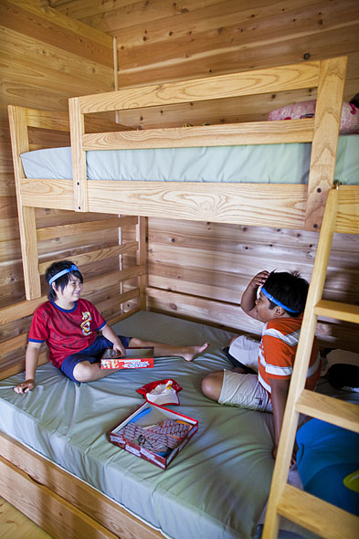 kids play a card game on bunk beds