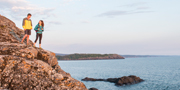 Two people hiking on the shoreline.