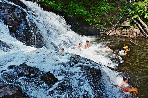 People bathing in waterfalls at the foot of the falls