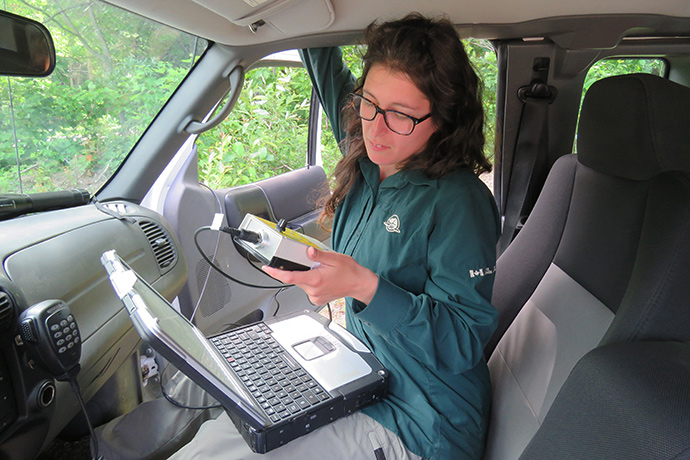 A Parks Canada employee installs an ultrasound detector in a vehicle.