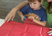 Young boy cutting tissue paper.