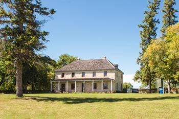 The historic St. Andrew’s Rectory on a summer day, surrounded by green trees.