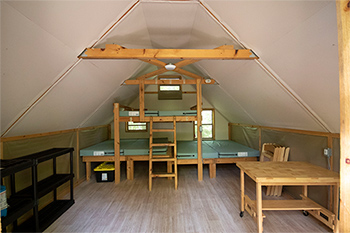 Interior of oTENTik showing bunkbeds that sleep 6, and a table and chairs