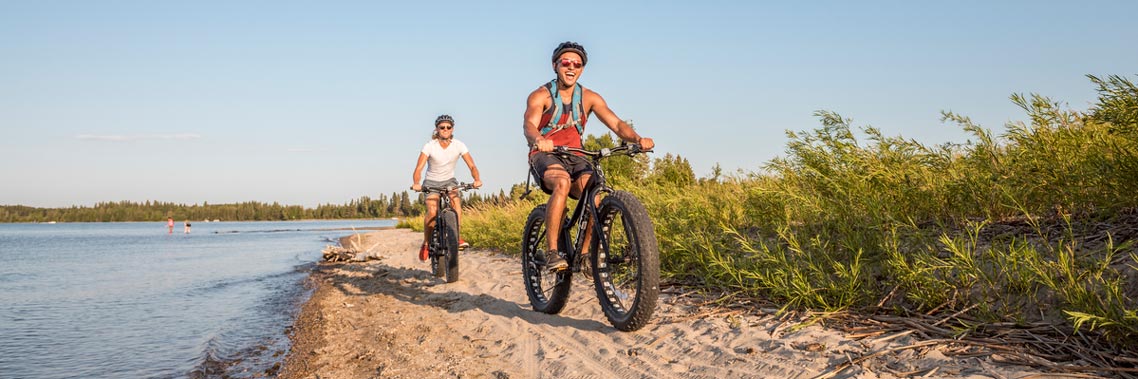 Visitors ride fat bikes along the beach on South Shore Trail.