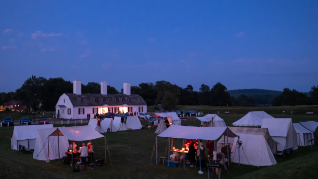 Tents on the grass to replicate an 18th century military camp in the evening. 