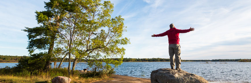 A hiker soaks up the shoreline scenery at Thumb Point on Beausoleil Island.