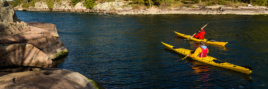 Two visitors kayak between islands at Thousand Islands National Park