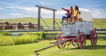 Two young women sitting on a chuckwagon