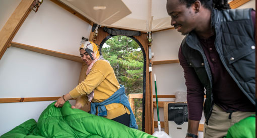 A couple setting up sleeping bags inside the Oasis.