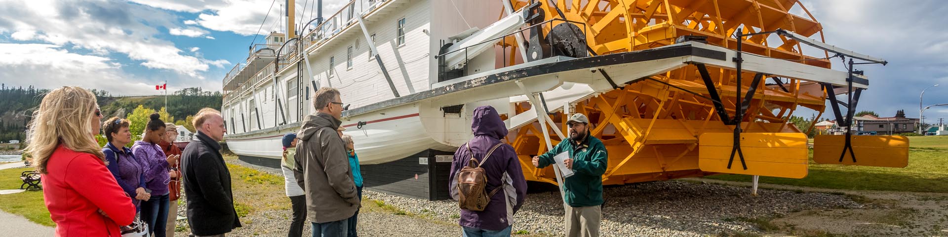 A Parks Canada interpreter talking to visitors next to the boat at the S.S. Klondike National Historic Site.